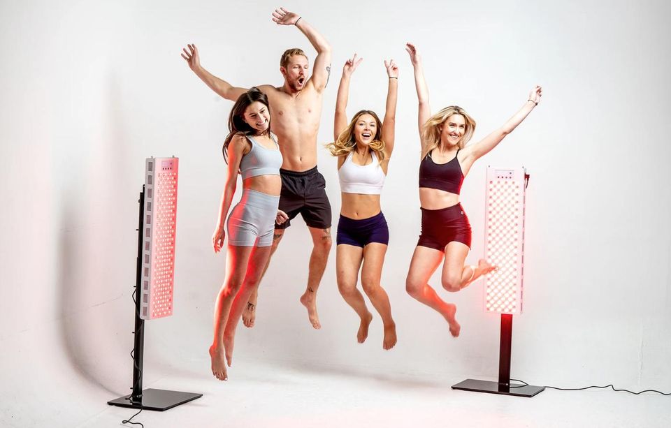 A group jumping joyfully beside RedRush panels