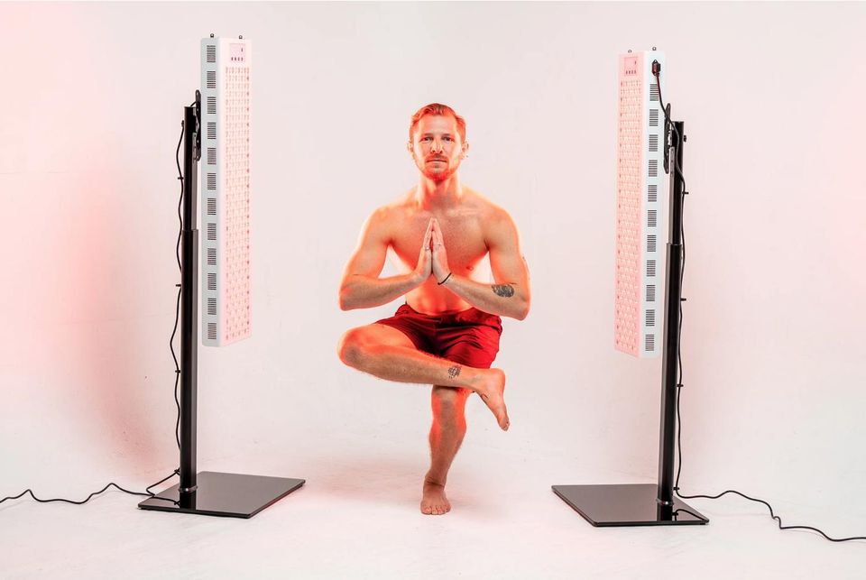 A man in a balanced yoga pose between two RedRush panels
